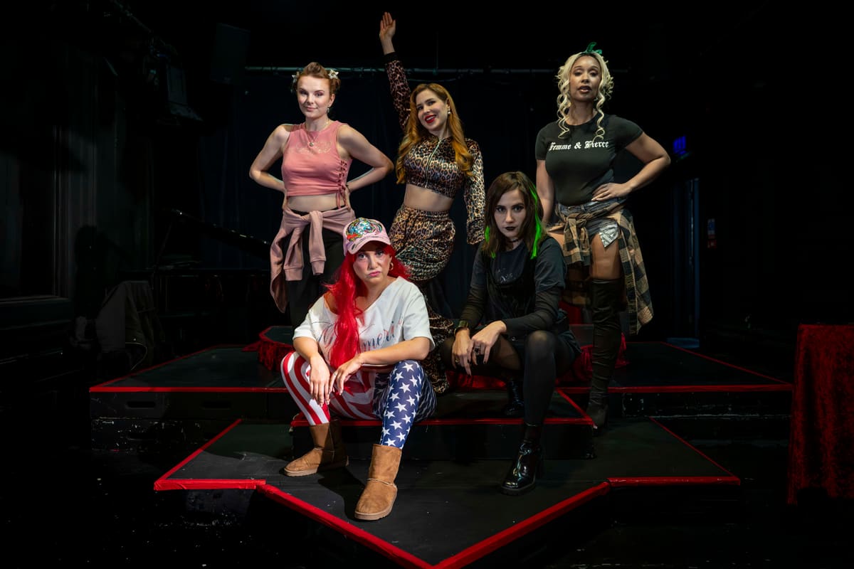 Five members of the Kitty Clap Klub cast pose together on a stage
